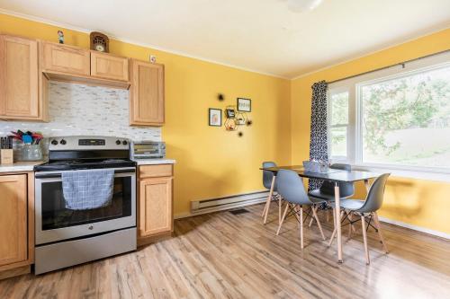 a kitchen with yellow walls and a table and chairs at Yinzer House - Whiteface Lake Placid Arcade Fun in Jay
