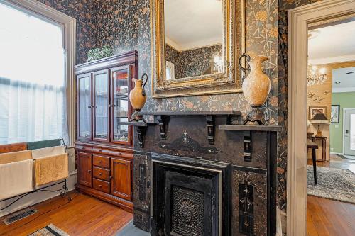 a living room with a fireplace and a mirror at Master King Room Victorian with Private Bathroom in a Historic house in Savannah
