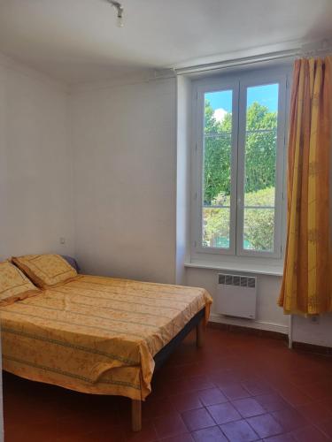 a bedroom with a bed and a window at Appartement avec piscine partagée in Boucoiran-et-Nozières