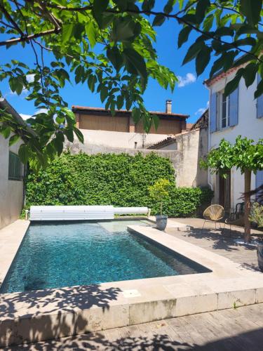 a swimming pool in front of a house at Appartement avec piscine partagée in Boucoiran-et-Nozières
