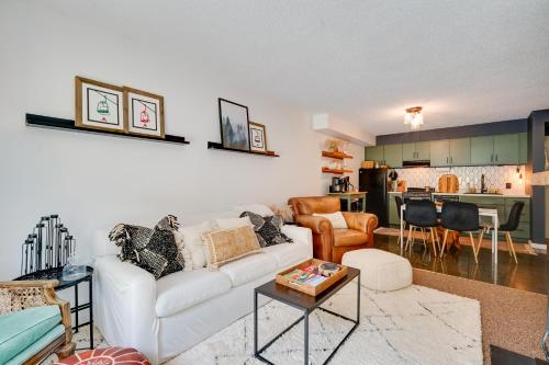 a living room with a white couch and a kitchen at Ski-InandSki-Out Magic Mountain Condo with Deck! in Londonderry