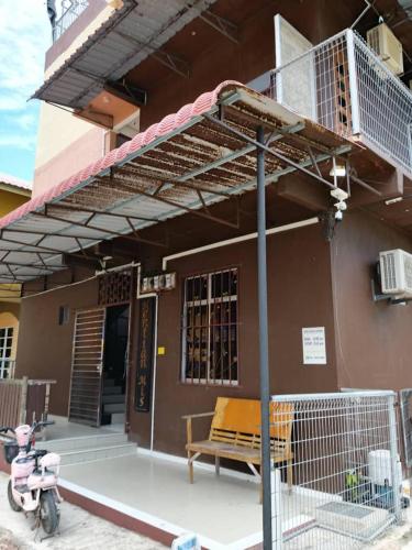 a porch of a house with a bench and a balcony at Perhentian MJ Fisherman Village in Perhentian Island