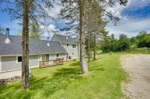 a white house with trees in the yard at Ski-InandSki-Out Magic Mountain Condo with Deck! in Londonderry