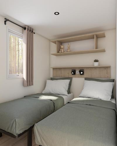 deux lits dans une chambre avec une fenêtre dans l'établissement Oasis des Garrigues, à Vogüé