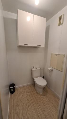 a white bathroom with a toilet and a cabinet at Joli 3 pièces proche RER D in Ris-Orangis