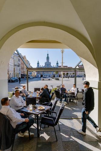 a group of people sitting at tables under an archway at Grandhotel Zvon in České Budějovice