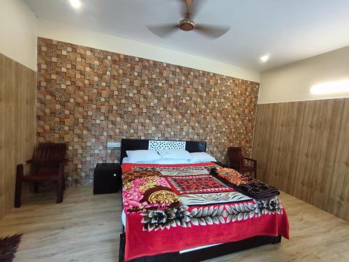 a bedroom with a bed and a brick wall at Golden Lake View Resorts in Yercaud