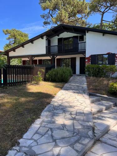 une maison avec une passerelle en pierre devant elle dans l'établissement Bask'aise o Pyla, à La Teste-de-Buch