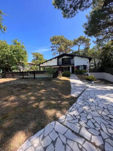 une maison avec une clôture et une allée en pierre dans l'établissement Bask'aise o Pyla, à La Teste-de-Buch