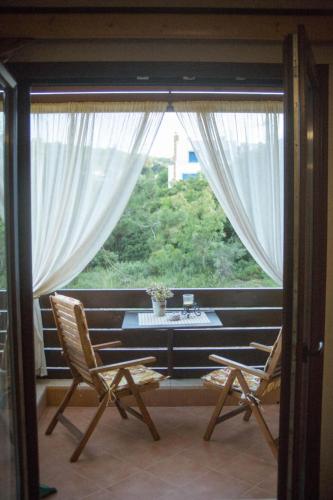 a room with two chairs and a table and a window at AnnaDes Apartments & Studios Chios in Karfas