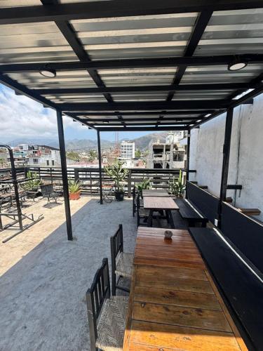 a patio with a wooden table and benches on a roof at Canova Hostel & Pizza in Puerto Vallarta