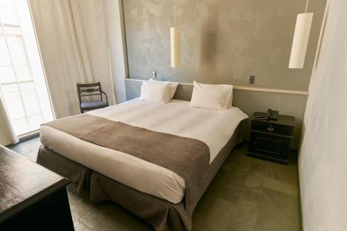 a bedroom with a large bed in a room with a window at Hotel Fundador in Santiago