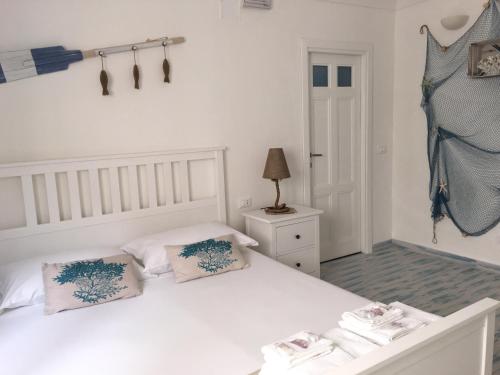 1 dormitorio con 1 cama blanca y 2 almohadas en Il Corallo, en Marettimo