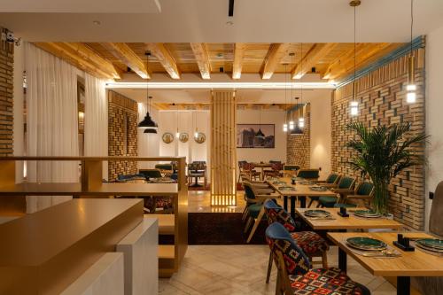 a restaurant with tables and chairs in a room at Sarhad Hotel in Bukhara