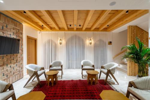a waiting room with chairs and a red rug at Sarhad Hotel in Bukhara