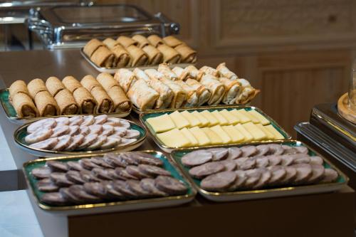 a table with trays of different types of cookies and pastries at Sarhad Hotel in Bukhara