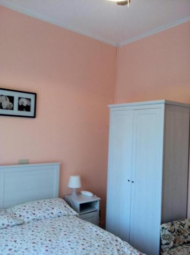 a bedroom with a bed and a white cabinet at Hotel Milanesina in Alassio