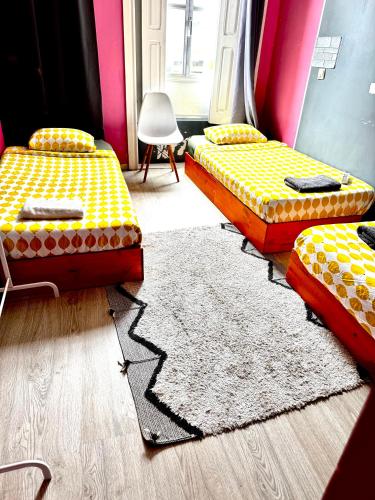 a room with three beds and a rug at Ndussole Guest House in Porto