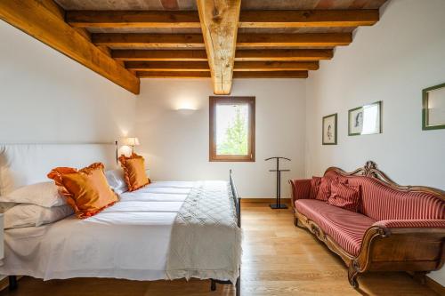 a bedroom with a large bed and a couch at Residenza Storica sulle Colline di Maranello in Fogliano