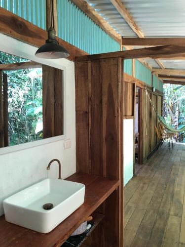 a bathroom with a white sink in a room at Amazing Cabin RIO LA MIEL in Estación El Salto