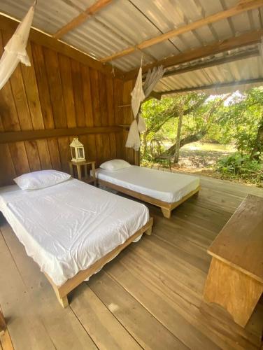 a bedroom with two beds in a wooden cabin at Amazing Cabin RIO LA MIEL in Estación El Salto