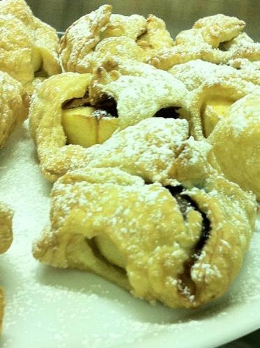 a pile of donuts with powdered sugar on a plate at Hotel Milanesina in Alassio