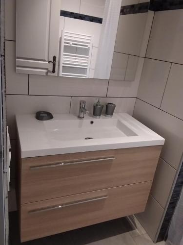 une salle de bain avec un lavabo et un miroir dans l'établissement jolie location, à Porto-Vecchio