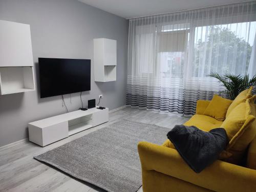パクシュにあるFeels like home Paksのリビングルーム(黄色のソファ、薄型テレビ付)