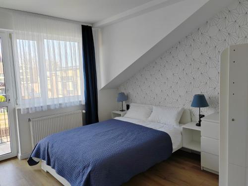 una camera da letto con un letto grande con una coperta blu di La Mare a Władysławowo