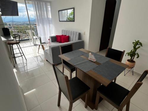 a dining room table and chairs in a living room at Apartamento Amoblado para estancias cortas in Pereira
