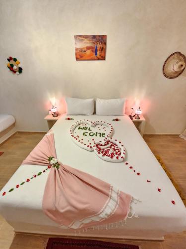 a bed with a heart made out of roses at Les Jardins d Amizmiz 6 piscines in Marrakech