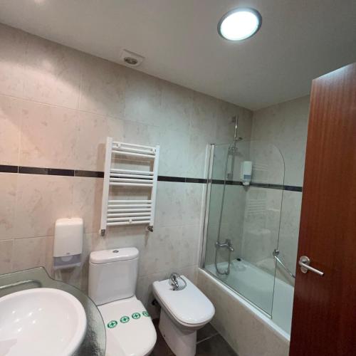 a bathroom with a toilet and a sink and a shower at Hotel Unzaga Plaza in Éibar