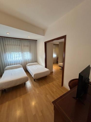 a hotel room with two beds and a mirror at Hotel Unzaga Plaza in Éibar