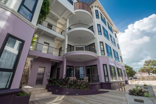 a purple building with a balcony at Diamante Beachfront Suites in San Pedro