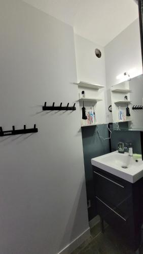 a bathroom with a sink and a white wall at Update Location in Lanester