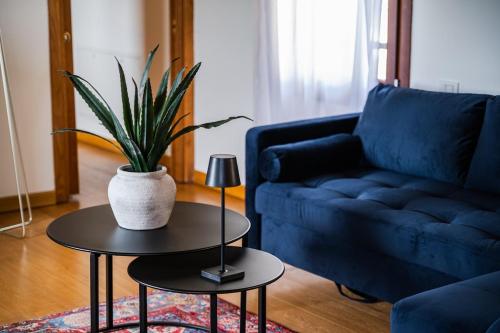 a living room with a blue couch and a table with a plant at Residenza Storica sulle Colline di Maranello in Fogliano