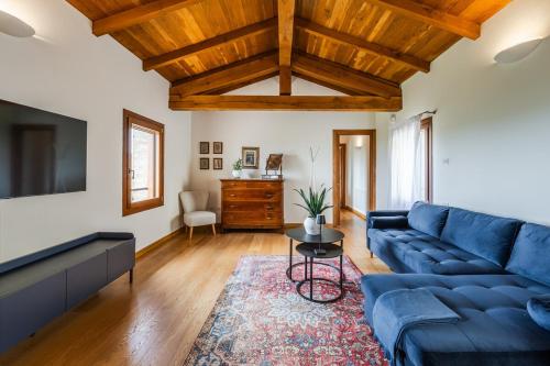 a living room with a blue couch and a tv at Residenza Storica sulle Colline di Maranello in Fogliano