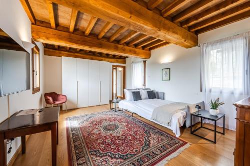 a bedroom with a bed and a tv and a rug at Residenza Storica sulle Colline di Maranello in Fogliano