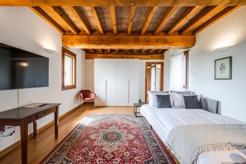 a bedroom with a bed and a desk and a tv at Residenza Storica sulle Colline di Maranello in Fogliano