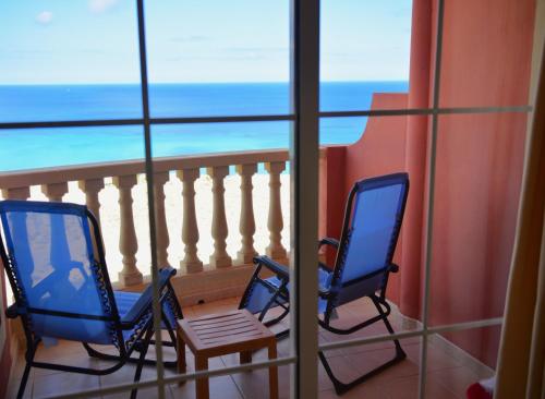 a room with two chairs and a balcony with the ocean at Relax, descanso y una experiencia inolvidable in Costa Calma
