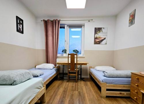 two beds in a room with a window at Rent Warszawa Ursynów in Warsaw