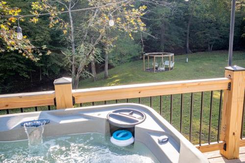 een badkuip met daarin een toilet op een terras bij Hot Tub - Fire Pit - River - State Park - King Bed in Wingina