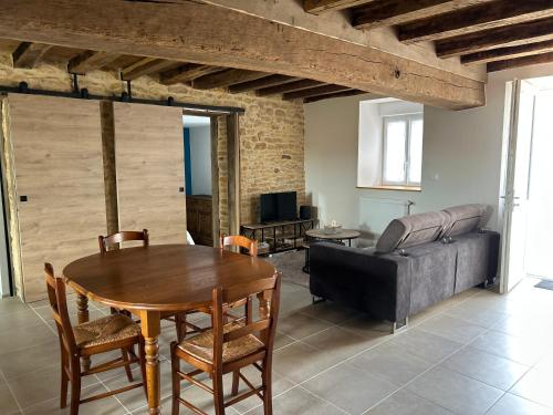 un salon avec une table et un canapé dans l'établissement Maison de campagne rénovée, à Montaron