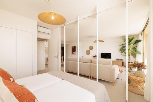 a bedroom with a white bed and a couch at Flamingos Salgados in Albufeira