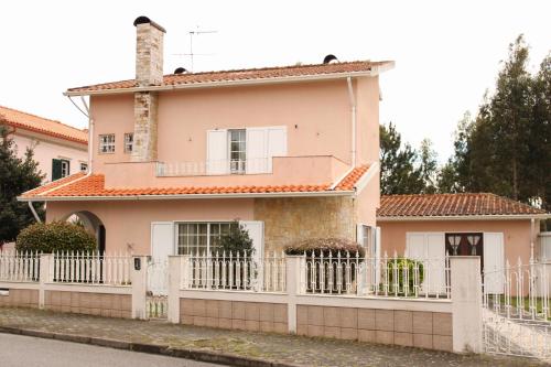 a pink house with a white fence at JP Guest House in Aveiro