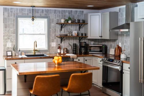 een keuken met een houten tafel en stoelen. bij Hot Tub - Fire Pit - River - State Park - King Bed in Wingina