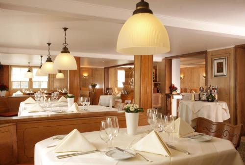 a restaurant with white tables and a large mirror at Idyllhotel Appenzellerhof in Speicher