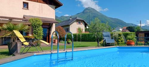 une maison avec une piscine et une montagne en arrière-plan dans l'établissement Maison - Piscine Parking Wifi - CLG Savoie, à Cruet