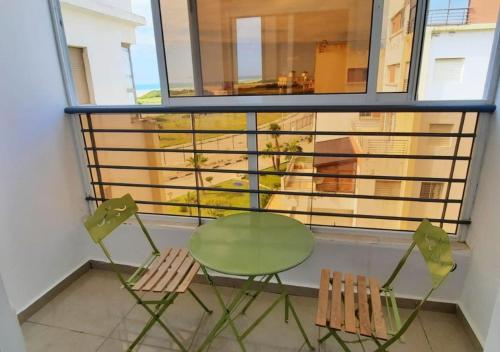 a green table and two chairs on a balcony at Apartment-Sea-view-sand-relaxation in Tangier