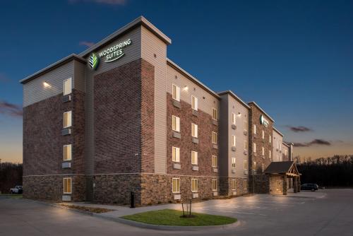 a large brick building with a sign on it at WoodSpring Suites Coralville Iowa City in Coralville